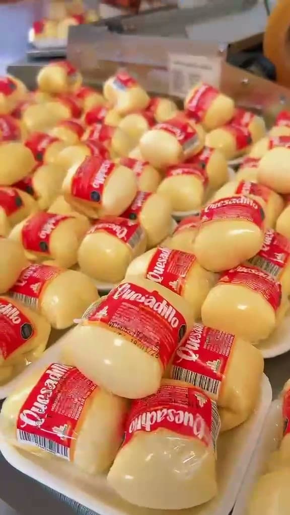 Quesadillas Lácteos Catambuco recién empacadas, con su etiqueta roja, sobre la mesa de la planta
